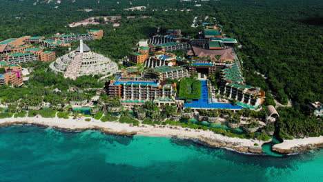 Flying-high-around-the-beautiful-Xcaret-Arte-Resort-and-the-tropical-beach-in-Playa-del-Carmen,-Quintana-Roo,-Mexico