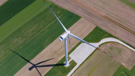 Aerial-orbit-over-the-modern-wind-turbine-in-the-middle-of-the-green-fields