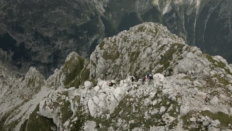 Drone-shot-of-the-mountain-Rombon-birds-eye-perspective,-looking-at-the-group-of-hiker-climbing-at-the-top