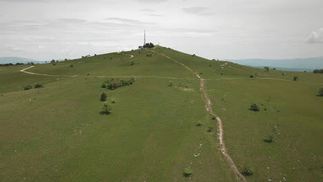 Drone-shot-of-the-top-of-mountain-Slavnik-with-green-meadows-and-off-road-paths-to-the-top-where-is-radio-tower