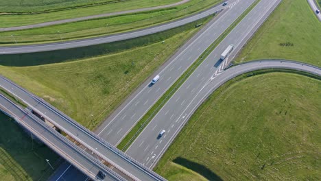 Aerial-Birdseye-view-traffic-driving-across-Icelandic-highway-roundabout-infrastructure