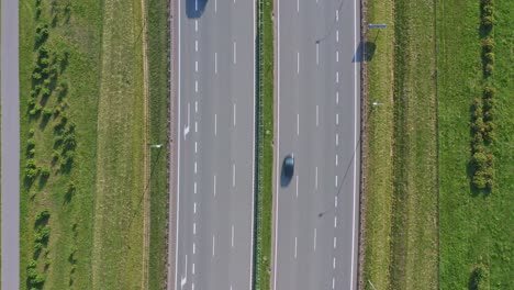 Highway-with-vehicles-flowing-in-opposite-directions---overhead-drone