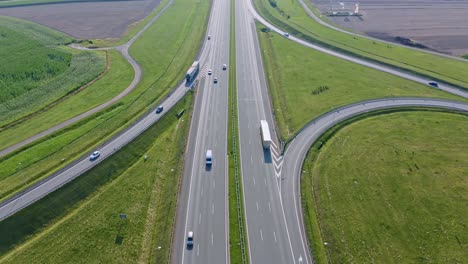 Wide-aerial-pull-out-of-highway-traffic-and-green-fields-in-Poland