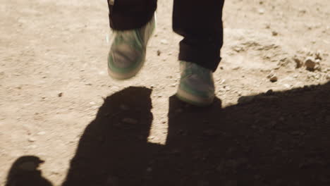 Guy-with-white-shoes-walking-in-the-dusty-dessert-in-the-hot-sun