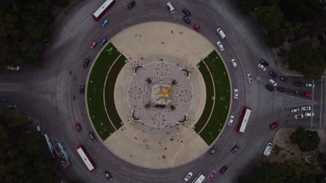 Cinematic-drone-shot-of-the-Angel-of-Independence-while-vehicles-circulate-in-the-roundabout-during-a-cloudy-day