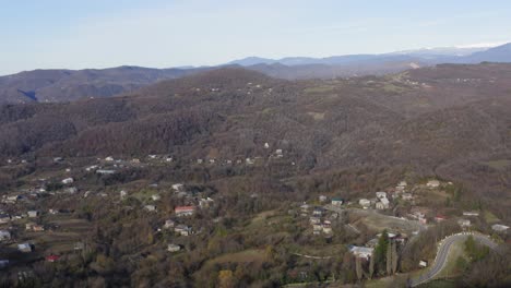Drone-of-Kutaisi-rural-village-in-winter-on-the-hills-with-river-and-houses,-georgia