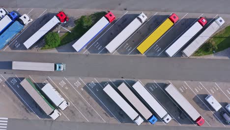Truck-drives-through-middle-of-diagonally-parked-trucks---top-down-aerial