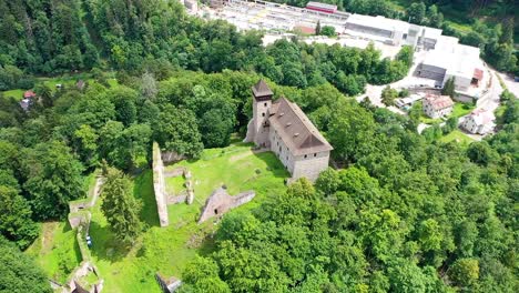 Old-small-castle-on-a-small-hill-surrounded-by-trees-beautiful-nature-location---drone-shot