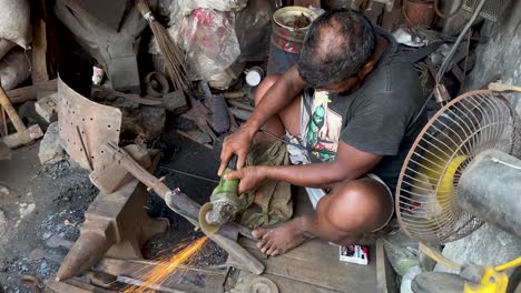 Schmied-Poliert-Eisenmesser-Mit-Winkelschleifer-In-Seinem-Geschäft-In-Bangladesch
