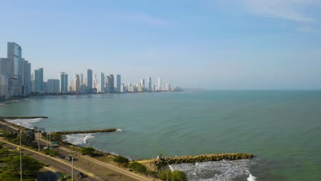 Modern-Cartagena-Skyline,-Low-Birds-Eye-Aerial-View-with-Cars-Driving-on-Highway