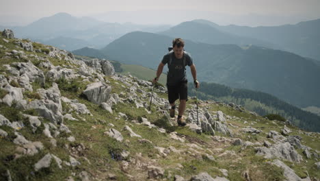 Wanderer-Climbin-Auf-Dem-Berg-Raduha-In-Richtung-Kamera,-Tal-Und-Andere-Berge-Im-Hintergrund-Sichtbar,-Teilweise-Bewölkt