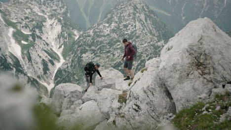 Two-hikers-meet-in-the-moutains,-one-gives-another-something-in-the-hand