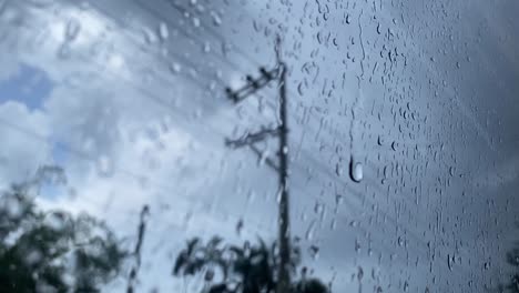 Sicht-Schuss-Von-Regentropfen-Auf-Fensterglas-Nach-Starkem-Regen-Mit-Dem-Verschwommenen-Bewölkten-Himmel-Vor-Dem-Fenster