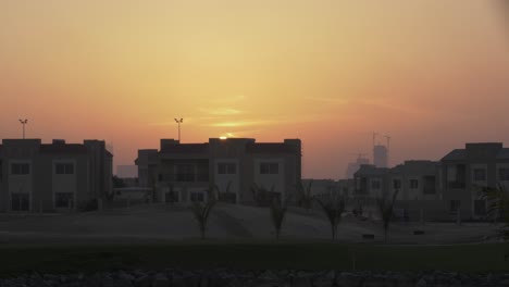 Sunset-in-the-evening,-dusk,-over-homes-in-middle-eastern-city-of-Dubai---United-Arab-Emirates