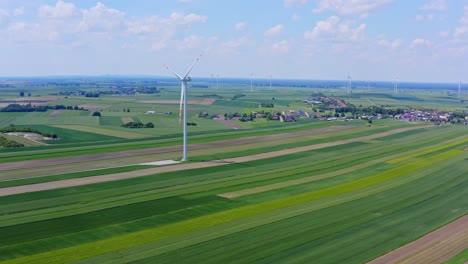Aerial-shot-of-the-wind-farm-in-the-agricultural-surroundings-on-a-sunny-day