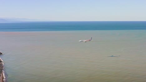 Aircraft-landing-above-Black-sea-and-touching-down-the-runway-in-domestic-airport-at-Batumi,-Georgia