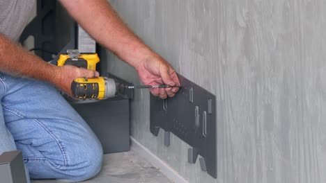 Technician-using-a-drill-to-install-the-hanging-bracket-for-the-battery-box-supports