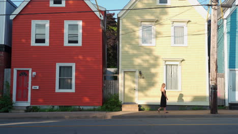 Casas-Coloridas-Con-Una-Mujer-Caminando-Frente-A-Ellas-Por-La-Mañana-En-Halifax,-Nueva-Escocia