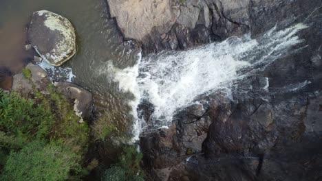 Wunderschöne-Aufnahme-Eines-üppigen-Wasserfalls,-Gefilmt-Mit-Einer-Drohne,-Die-In-Dichtem-Wald-Zu-Bäumen-Aufsteigt