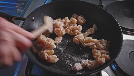 Person-Stir-Frying-Breast-Chicken-Cut-In-Cubes-And-Breaded-With-Flour