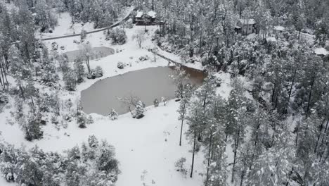 Aerial-shot-of-a-pond-surrounded-by-snow-in-Arizona