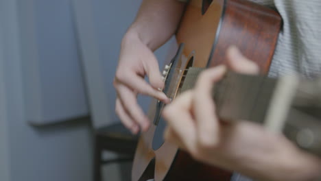 Slow-motion-footage-of-a-person-strumming-an-acoustic-guitar-in-a-recording-studio