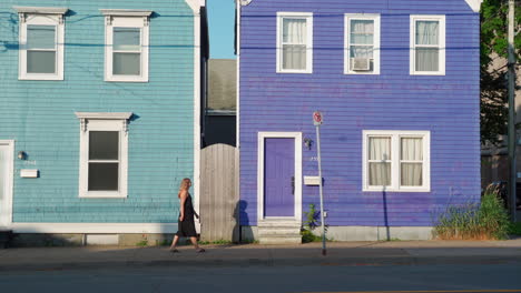 Casas-Coloridas-Con-Una-Mujer-Caminando-Frente-A-Ellas-Por-La-Mañana-En-Halifax,-Nueva-Escocia