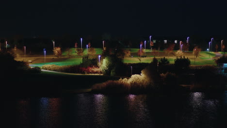 Beautiful-landscape-of-Pae-park-alongside-pond-illuminated-with-night-light,-Tallinn,-Estonia