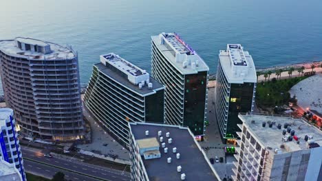 Aerial-view-of-modern-residential-buildings-at-seaside-of-Batumi-city-at-evening-dawn
