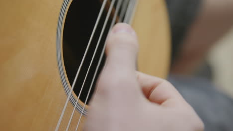 Slow-motion-footage-of-a-thumb-strumming-on-the-strings-of-a-guitar