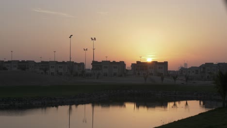 Sunset-behind-buildings-in-the-evening,-dusk,-over-homes-in-middle-eastern-city-of-Dubai---United-Arab-Emirates