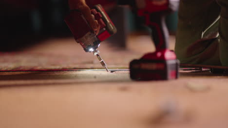 Close-Up-Tradesman-Hands-Prying-Bolt-Out-Of-Floor-With-Power-Tool-Drill,-4K