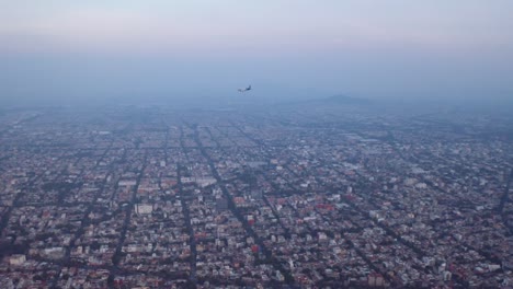 Commercial-airplane-flies-over-Mexico-City-at-blue-hour,-after-sunset