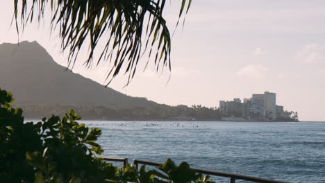 Surfing-Line-Up-Paddling-in-Waikiki-Bay-at-Sunrise,-Diamond-Head-in-the-Distance