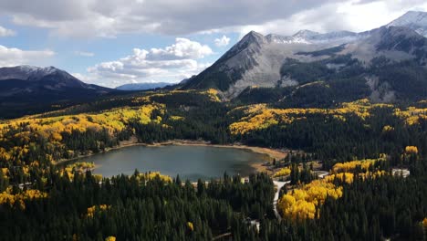 Drone-flying-over-Lost-Lake-with-fall-tree-colors-and-mountains,-on-Kebler-pass-Colorado