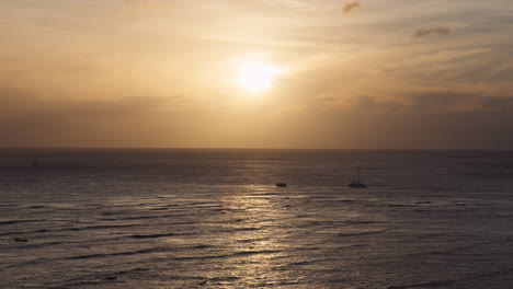 Low-Sunset-Golden-Hour-at-Waikiki-Bay,-Ships-on-Horizon-Amid-Ocean-Waves,-Hawaii