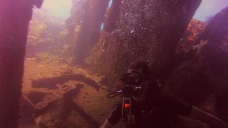 Diver-entering-sunken-ship-wreck-uss-liberty-scuba-diving-in-bali-indonesia