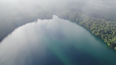 Aerial-View-Through-Clouds-Of-Lake-Eacham-In-Tropical-North-Queensland,-Australia