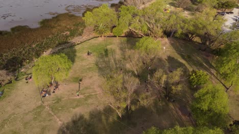 Eine-Dynamische-Luftaufnahme-Eines-Mannes-Auf-Einer-Slackline,-Der-Einen-Balanceakt-Durchführt,-Während-Er-In-Einem-öffentlichen-Park-In-Vicente-Lopez,-Buenos-Aires,-Hindurchgeht