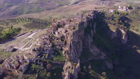 Craco-stone-building-abandoned-ghost-town-on-rocky-hill,-aerial