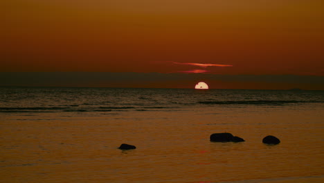 Himmel-Beleuchtet-Mit-Schönem-Licht-Bei-Sonnenaufgang-Durch-Meereshorizont-Und-Reflexion-Auf-Dem-Wasser