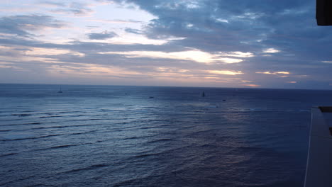 Yachten,-Die-Bei-Sonnenuntergang-Auf-Glitzernden-Ozeanwellen-Segeln,-Blick-Vom-Balkon,-Slomo,-Waikiki-Bay