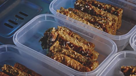 Baked-Mix-Vegetable-Snack-Bars-Topped-With-Sesame-Seeds-On-A-Rectangle-Plastic-Container