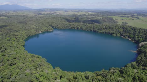 Exuberantes-Bosques-Tropicales-Que-Rodean-El-Lago-Eacham-En-Atherton-Tableland,-Queensland,-Australia---Disparo-De-Drones