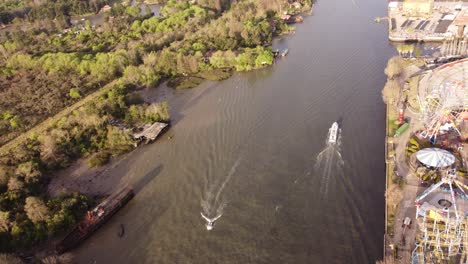 A-dynamic-aerial-footage-of-a-cruising-passenger-boats-along-the-riverside-of-Parque-de-la-Costa-amusement-park-at-the-Tigre-area-in-Buenos-Aires