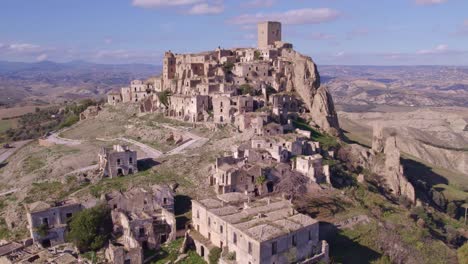 Ancient-hill-top-stone-house-village-in-Italy-badlands,-aerial