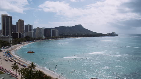 Tourists-Enjoying-Waikiki-Beach-on-Sunny-Day-With-Diamond-Head-in-Background,-Hawaii,-Aerial