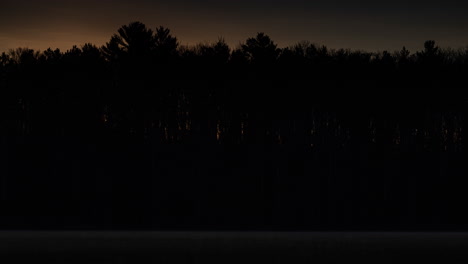 Zeitraffer-Des-Sonnenaufgangs-Durch-Die-Bäume-Auf-Der-Anderen-Seite-Eines-Kleinen-Sees-Im-Norden-Von-Michigan