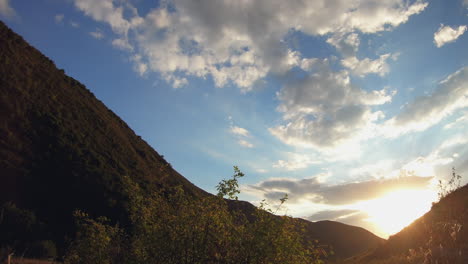 Timelapse-of-mountain-valley-at-sunset,-with-clouds-moving-across-the-sky