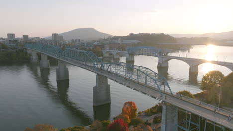 Aerial-footage-rotating-around-the-Walnut-Street-bridge-while-people-walk-across-during-sunset-in-Chattanooga,-TN